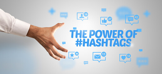 Close-Up of cropped hand pointing at THE POWER OF #HASHTAGS inscription, social networking concept