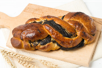 bread roll with poppy seeds on a white table