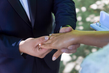 Obraz na płótnie Canvas the groom puts the ring on the bride's finger