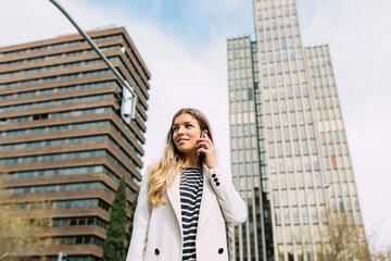 Confident businesswoman using smartphone in the street
