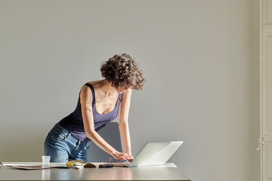 Woman in earphones working on computer.