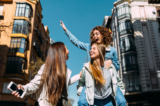 Cheerful young women having fun on street