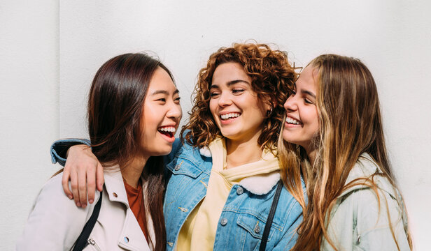 Happy friends looking at camera on white background