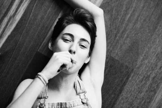Monochrome portrait of girl smoking on floor