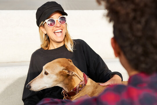 Pretty blonde girl with dog laughing.