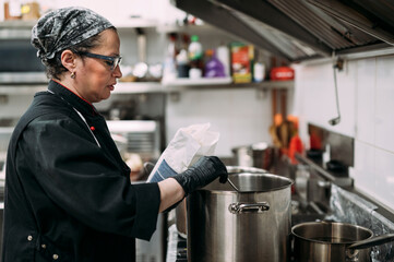Female chef cooking in industrial kitchen
