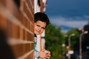 Little boy applauding in his window in gratitude to the health personnel and other groups during the confinement for the coronavirus