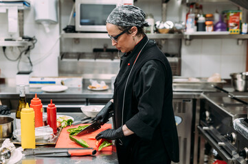 Female chef cooking in industrial kitchen