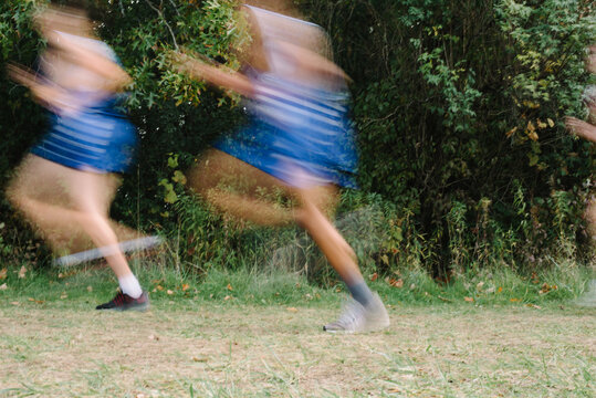 Blurry cross-country runners on an outdoor path
