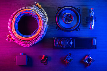 A car audio equipment on the table in the neon lights background.