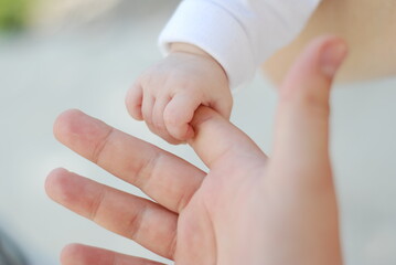Newborn baby girl holding finger