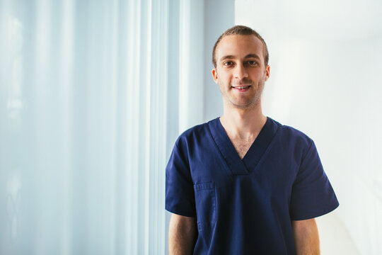 Portrait of happy doctor in hospital corridor