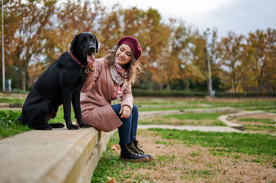 Girl with black Labrador in park