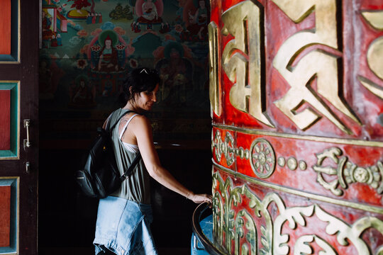 Woman spinning a big prayer wheel