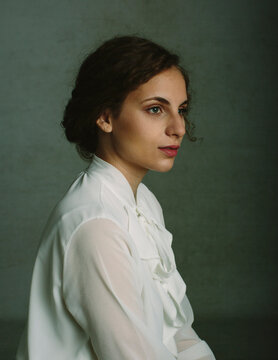 Classic portrait of beautiful woman over grey textured background.