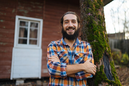 portrait of a smiling bearded guy in a plaid shirt