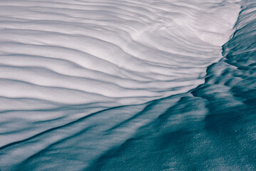 Snow creates patterns when it melts under the warm sun
