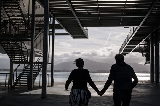 A couple runs together holding hands