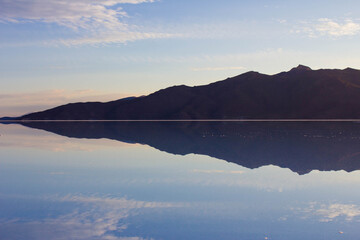 Clouds and mountain are reflecting in the water on salar de Uyuni