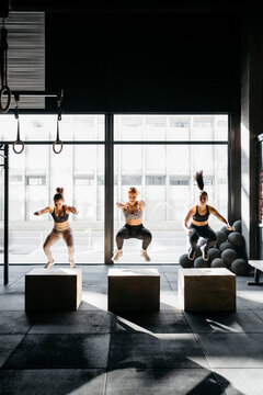 Group of women box jumping during a crossfit training