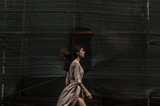 a slender girl with dark hair walks past the stratum net