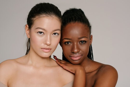 Closeup of Asian and black girls on the neutral background