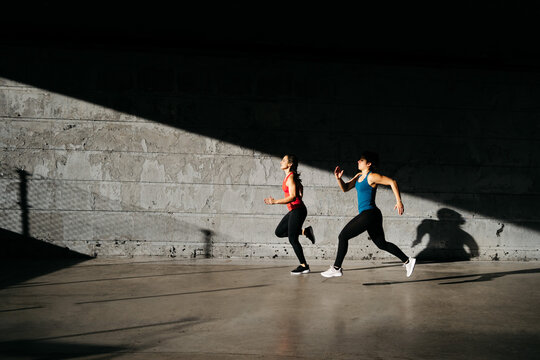 Active young female athletes jogging on stadium