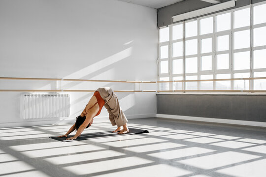 Sportive woman standing in downward facing dog pose
