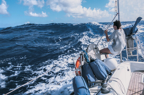 a sailor is sitting on the edge of a yacht