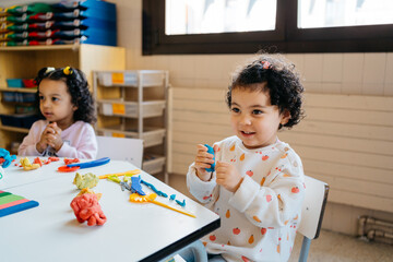 Mixed race kids playing with modeling clay