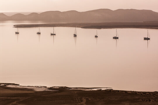 7 anchored boats in hazy light