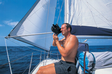 a sailor is using a sextant to determine his location