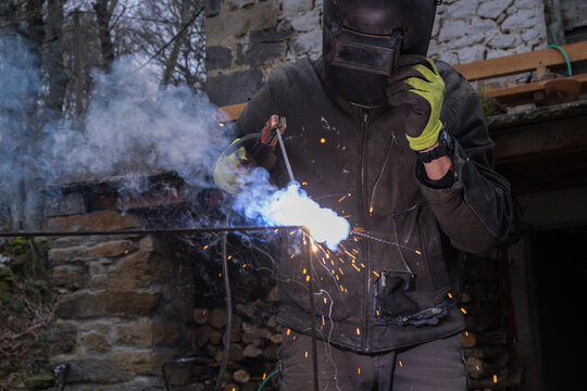 a man using protective gear is welding
