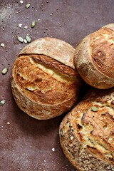 Homemade Freshly Baked Country Bread  made from wheat and whole grain flour on brown background. French Freshly baked bread. 