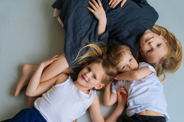 three happy children are lying on the floor