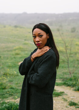 Portrait of black woman with coat outdoors looking at camera