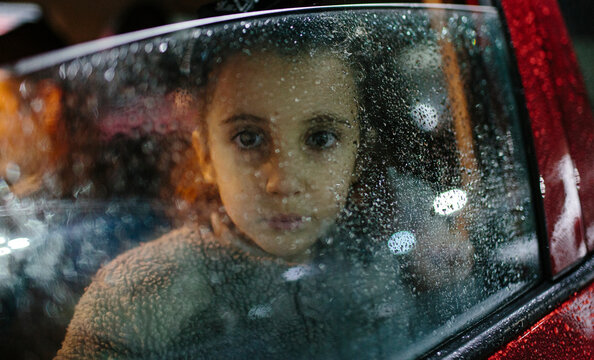 Little Girl In The Rain Inside A Car