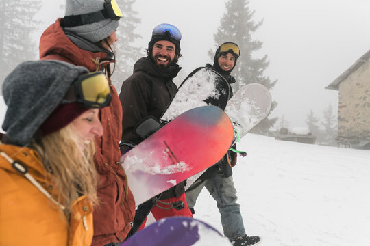 Friends having fun together during a day on the snowboard into the wild