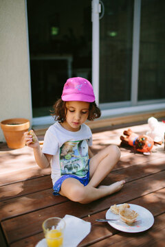 Kid having a breakfast picnic on the porch