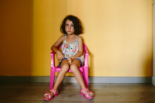 Kid grounded on a chair