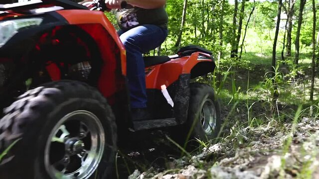 Long shot. Slowmotion. Guys, men on an ATV ride up the hill. Quad bikes in the forest. Quad bike ride. Active rest on ATVs.