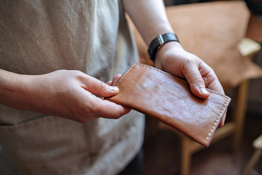 close up of hands holding a leather product