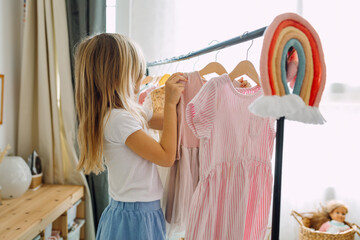 Girl choosing dresses on a clothing rack