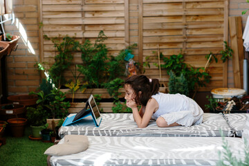 Kid looking at a tablet in a terrace