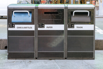 Trash waste bin in New York city street litter bins with cups of coffee on recycling garbage