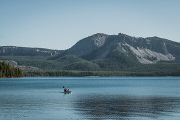Fototapeta na wymiar people kayaking on lake and near the mountains