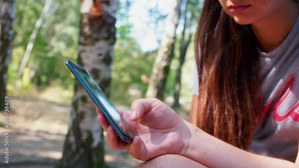 Poster close-up of the phone in the hands of a man. the guy does moving your finger across the screen, scro