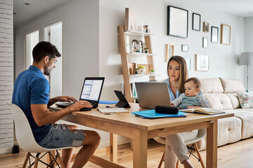 Young parents with baby working at home