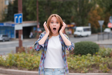 Portrait of a beautiful girl on the street who shows surprise