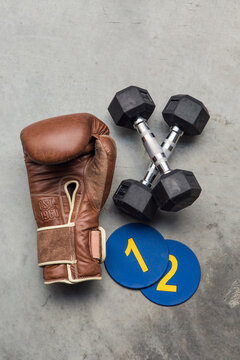 Brown leather boxing gloves with dumbells and number plates